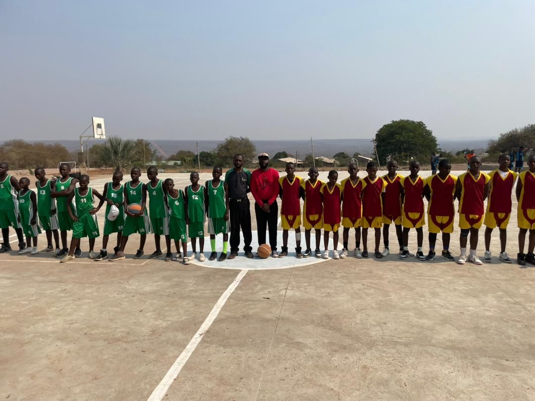 Two junior school teams lined up across the halfway line before a league fixture