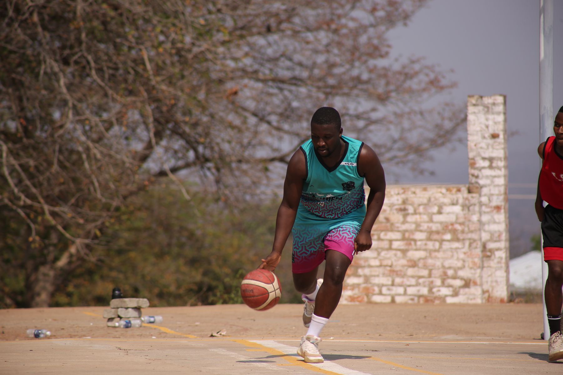 A Panthers guard driving to the basket in the club's teal and magenta kit