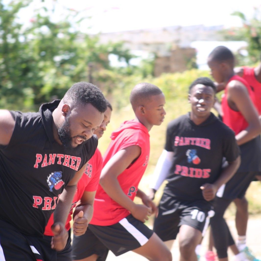 Junior players and a coach running a warm-up drill