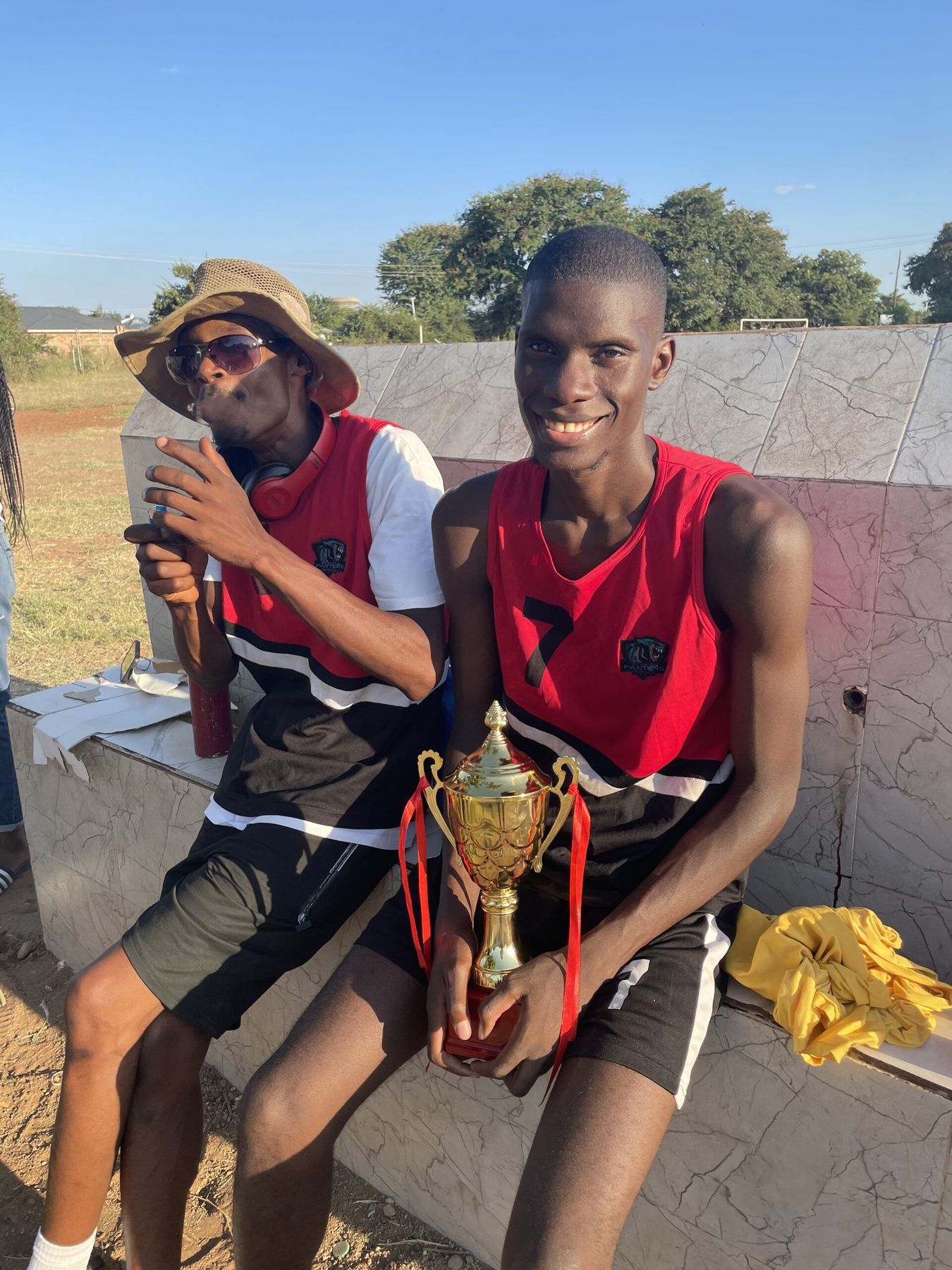 A Panthers player holding a tournament trophy courtside